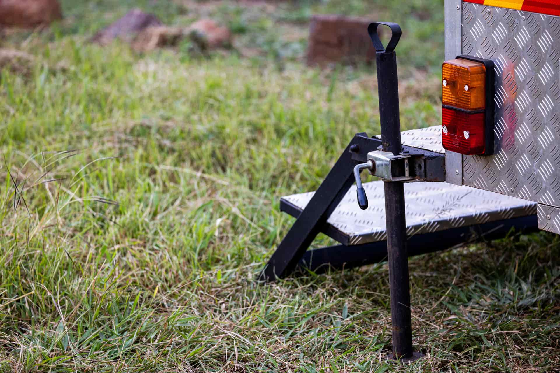 A trailer stabilizer jack lowered onto a support pad